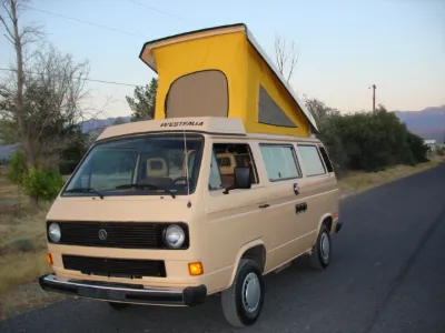 Beige VW Vanagon Westfalia with yellow pop-top raised